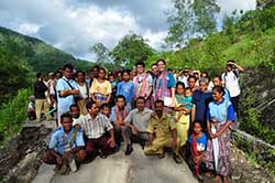 Photo of OFDA worker with Indonesian men, women and children.