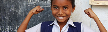 Photo of a girl smiling and holding up her hands.