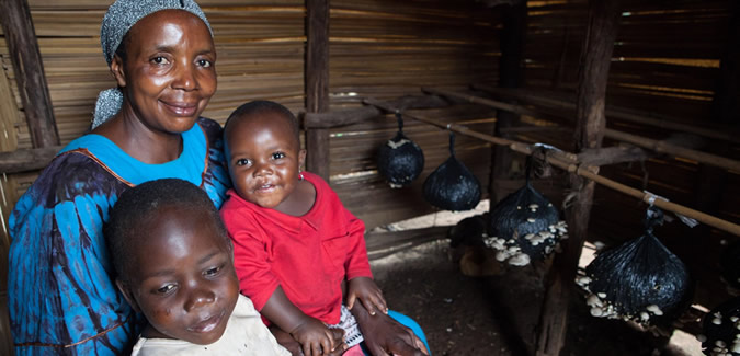 A woman sits inside with two children