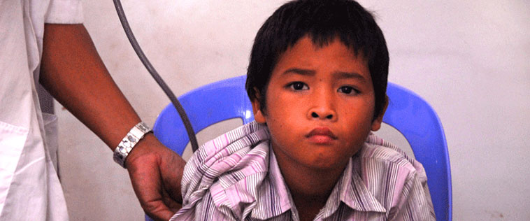 A clinician listens to a young boys breathing.