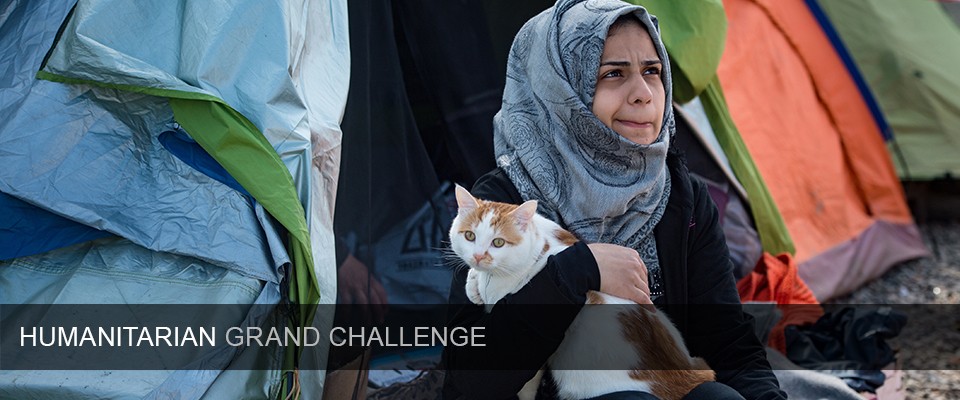 A girl holds Taboush, a cat travelling with a migrant family from war-torn Syria to Europe, in front of a tent in a makeshift camp at the Greek-Macedonian border near the village of Idomeni on March 21, 2016.  Greece will not be able to start sending refugees back to Turkey from March 20, 2016, the government said, as the country struggles to implement a key deal aimed at easing Europe's migrant crisis. The numbers are daunting: officials said as of Saturday there were 47,500 migrants in Greece, including 8